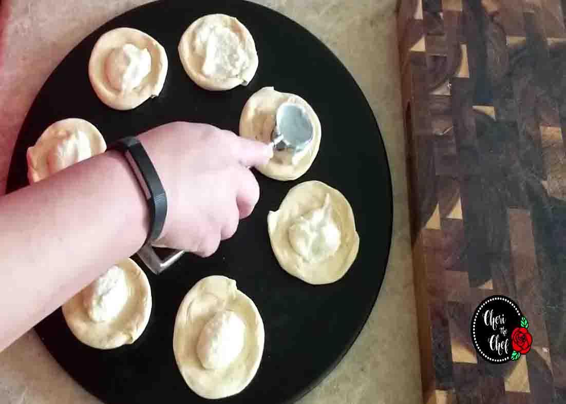 Spreading the cream cheese filling on the crescent rolls