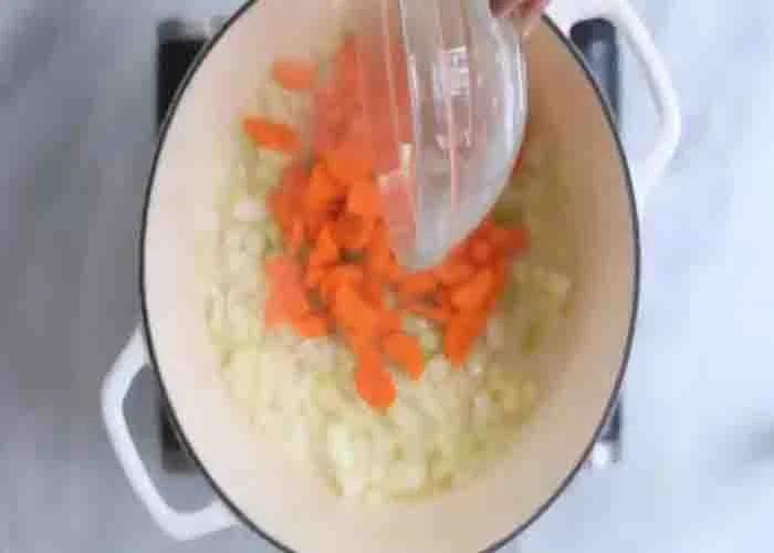 Adding the ingredients to the pot for the tuscan white bean soup recipe