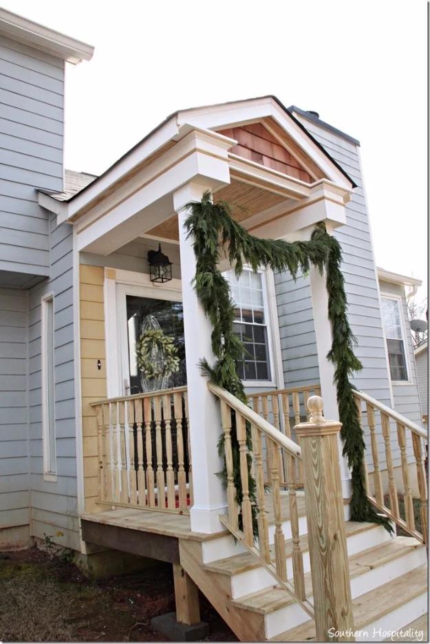 DIY curb appeal front portico with white columns, cedar shingle gable and new wood steps on a gray sided house