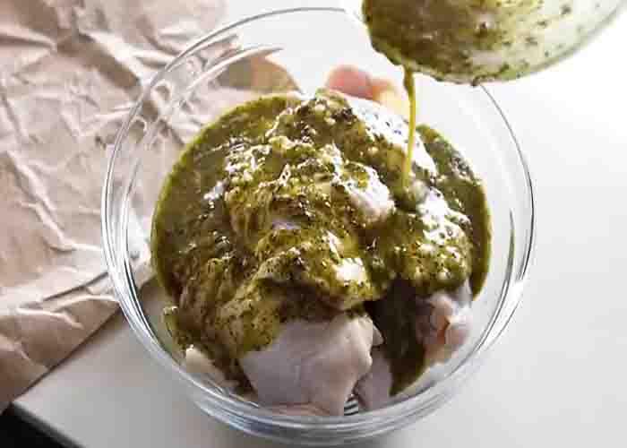 Coating the chicken thighs with Greek lemon dressing