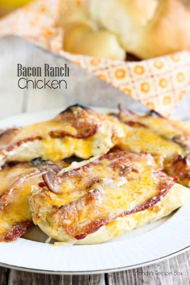 Pin graphic titled in grey script above a plate of bacon ranch chicken under melted cheddar, bread rolls behind