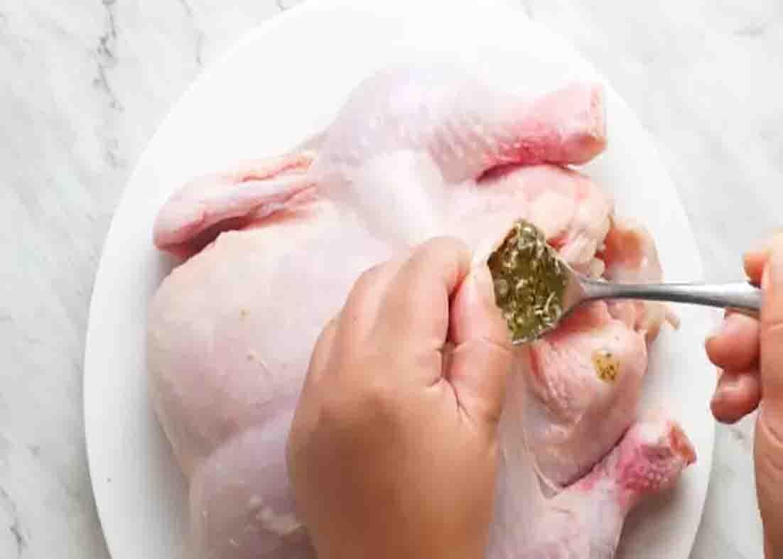 Rubbing the herb mixture under the chicken's skin before slow cooking