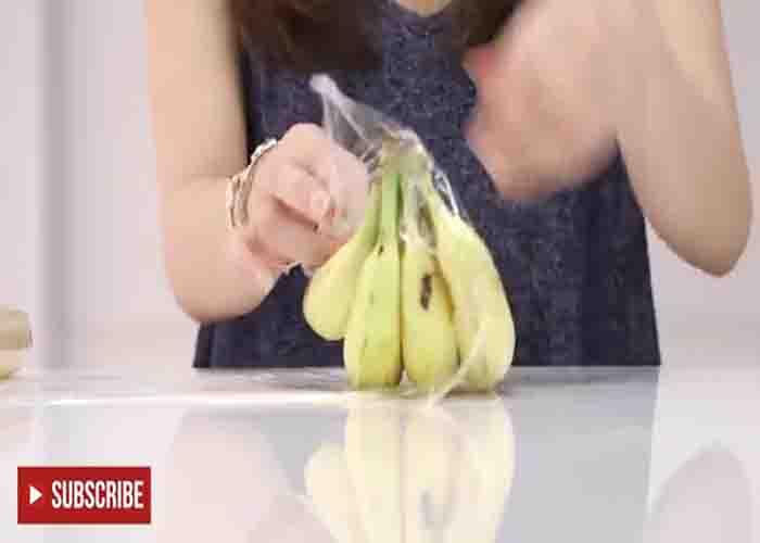 Wrapping the banana with plastic wrap to store it longer