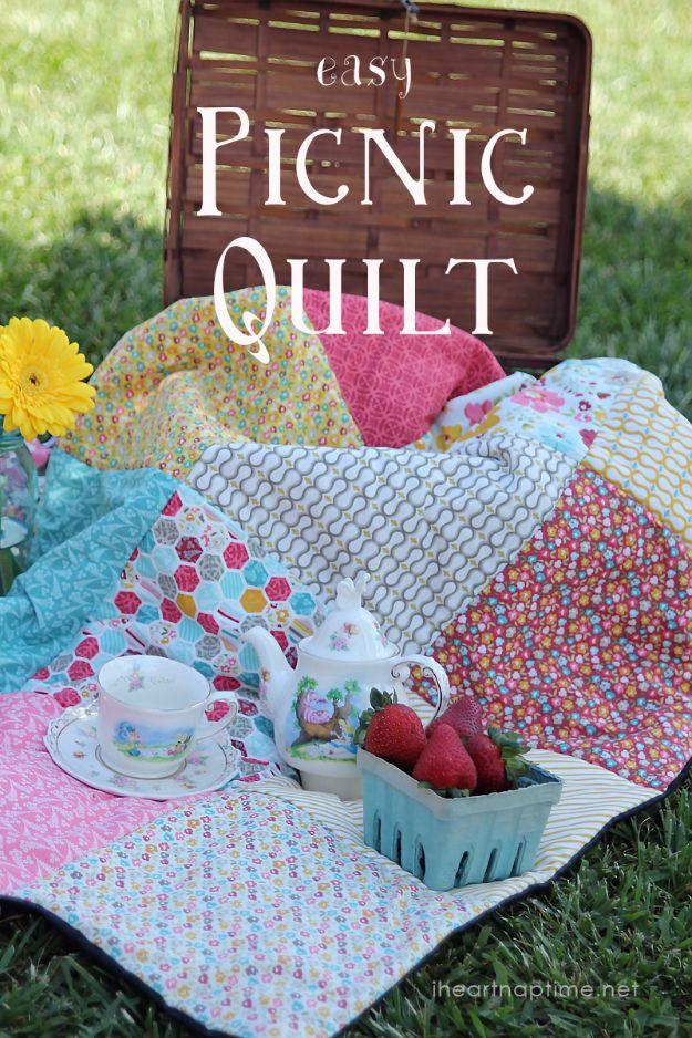 Easy picnic quilt, a mismatched floral patchwork quilt spread on grass with a tea set and strawberries in a berry basket