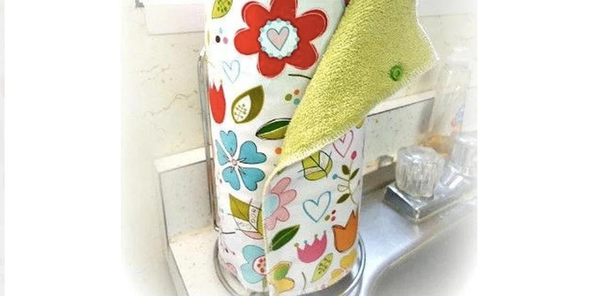 Roll of floral cloth unpaper towels standing on a kitchen counter with a green terry towel pulled from the top