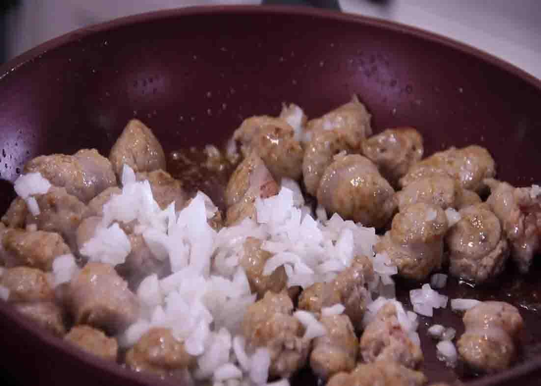Sauteing the Italian sausage and onions for the casserole recipe