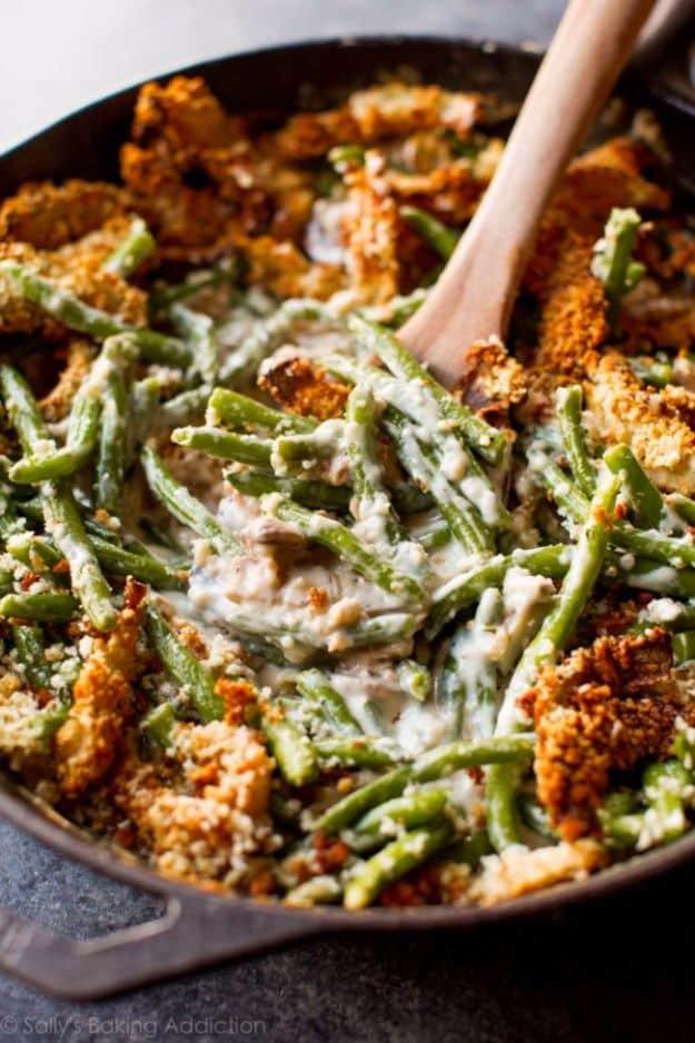 Creamy green bean casserole from scratch topped with golden panko crusted onion rings in a white baking dish