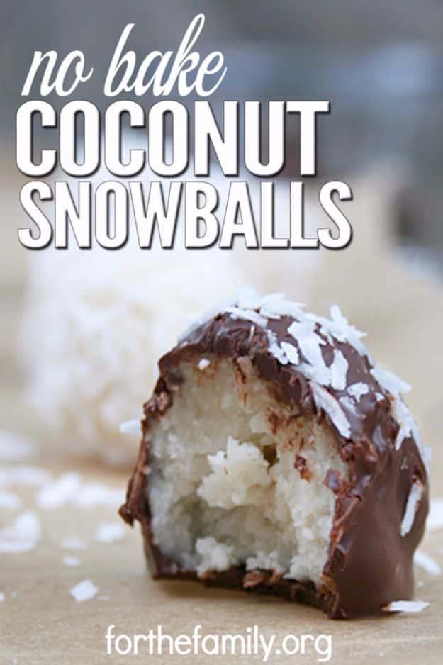 No bake coconut snowballs rolled in shredded coconut and dipped in dark chocolate on a white plate for a holiday tray