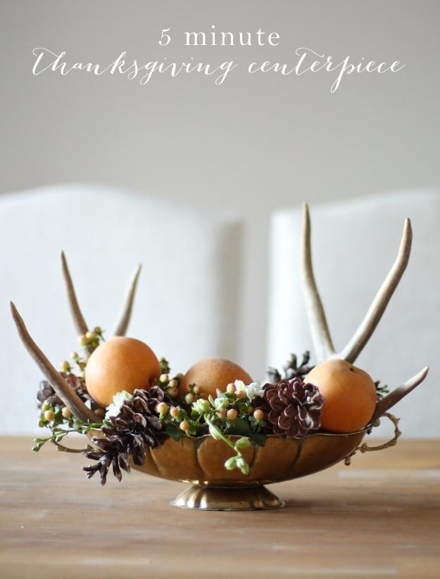 Five minute Thanksgiving centerpiece made from a silver bowl filled with pinecones and greenery with tall stems added