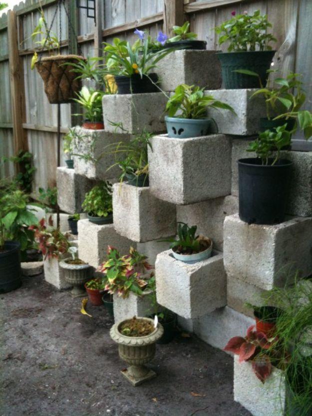Cinder block focal point vertical planter, a staggered open concrete block wall holding potted plants on its ledges