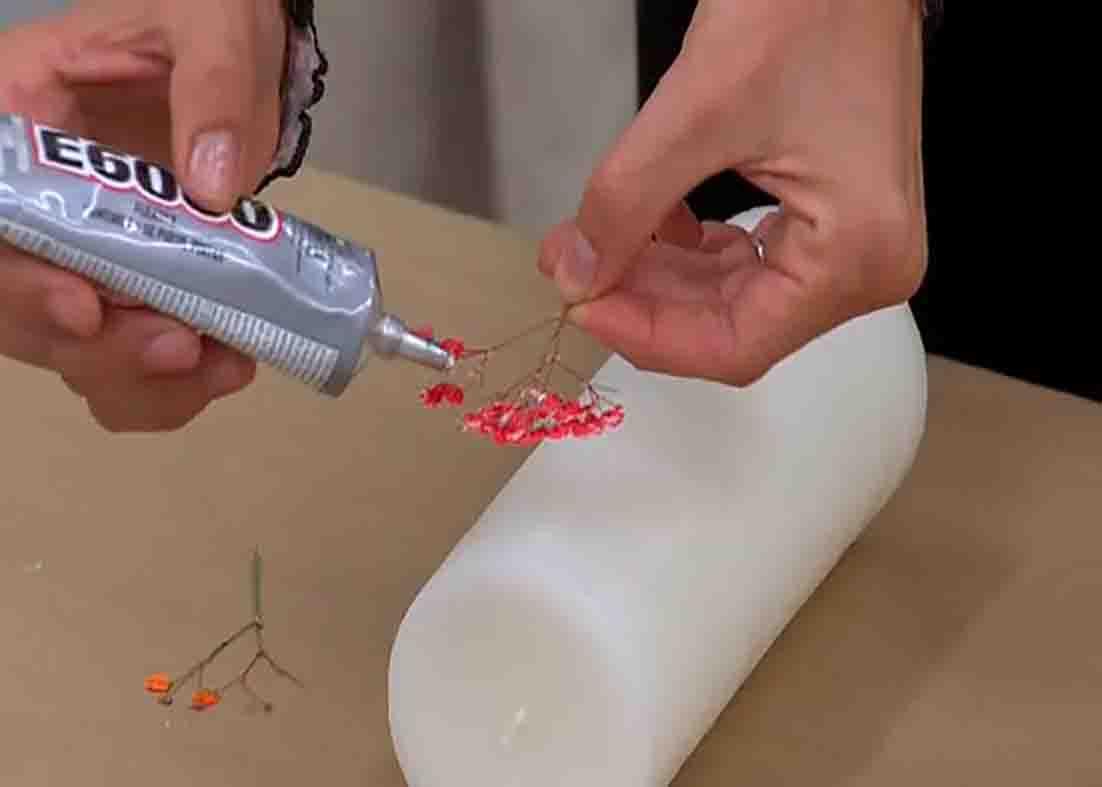 Gluing the pressed flowers onto the candle