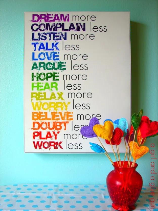 Large white canvas of rainbow colored motivational word pairs on a mint wall, red vase of fabric hearts on sticks beside it