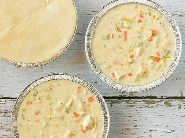 Chicken and leek pie filling in foil tins with raw pastry lids waiting, a comforting celebrity dinner recipe