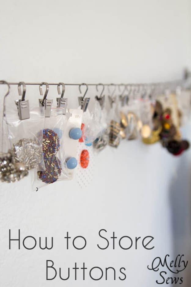 How to store and organize buttons, buttons in small bags and on cards hung from clips along a taut wire on a white wall
