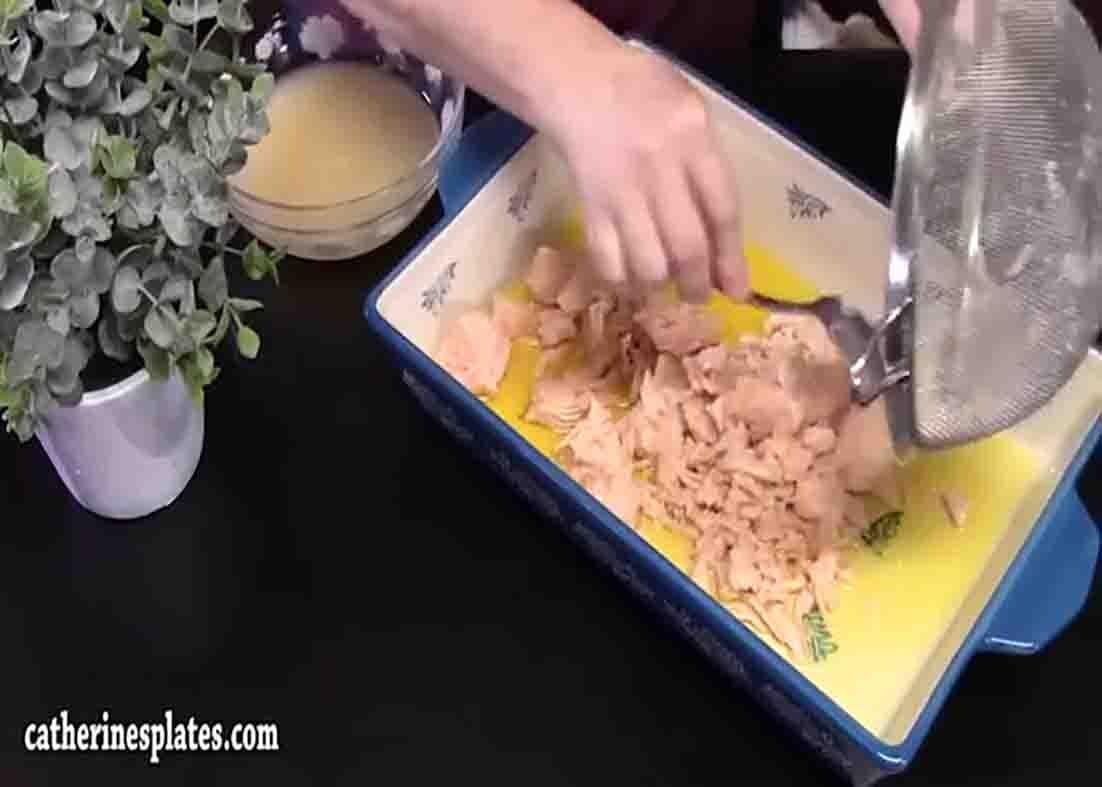 Adding the canned chicken to the greased casserole dish