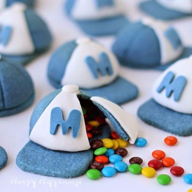Candy filled baseball cap pinata cookies shaped as domed caps in team colors, one broken open with candy
