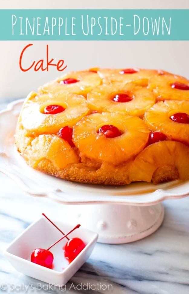 Pineapple upside down cake with caramelized pineapple rings and maraschino cherries on a white stand