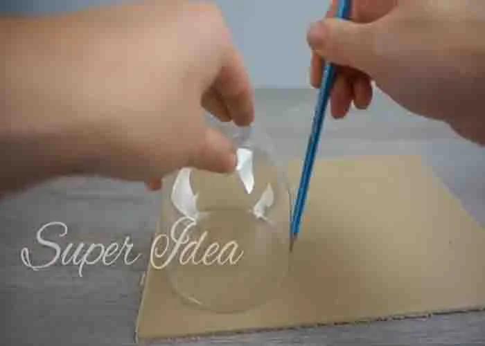 Tracing a circle shape on the cardboard to make the DIY snow globe