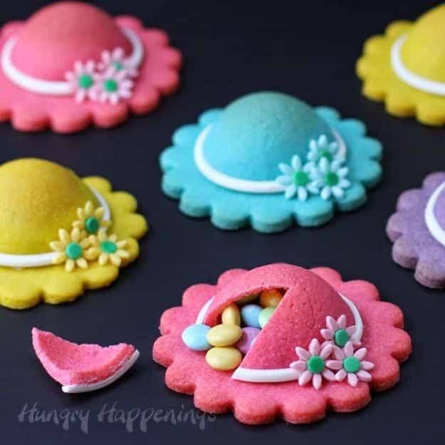 Ladies hat pinata cookies in pink, violet, blue and yellow with modeling chocolate flowers on the brims