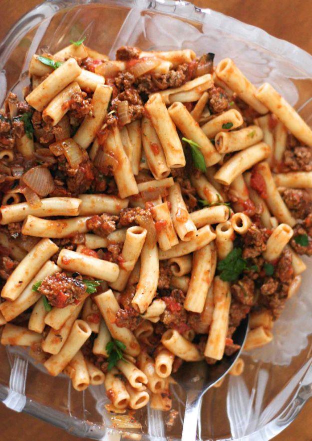 Penne pasta with meat sauce in a glass dish, tube pasta coated in a chunky ground beef and tomato sauce