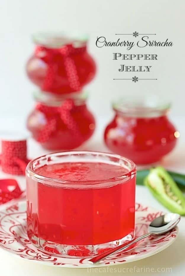 Cranberry sriracha pepper jelly poured over a block of cream cheese and served with crackers on a platter