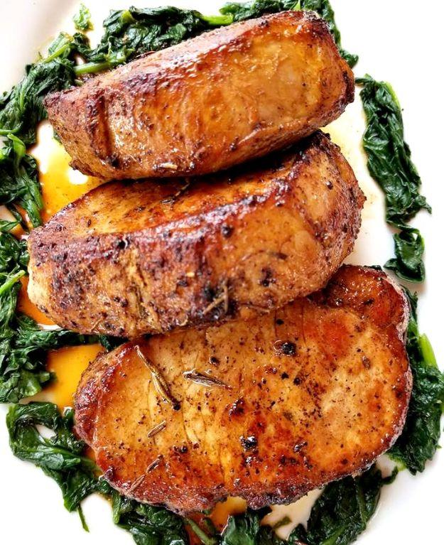 Rosemary garlic butter chops seared deep golden brown and stacked over a bed of bright wilted green spinach