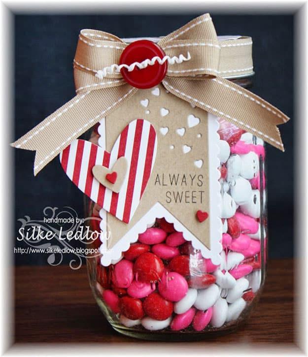 Mason jar gift decorated with layered paper rosettes and a tag on the lid for a pretty Valentine gift