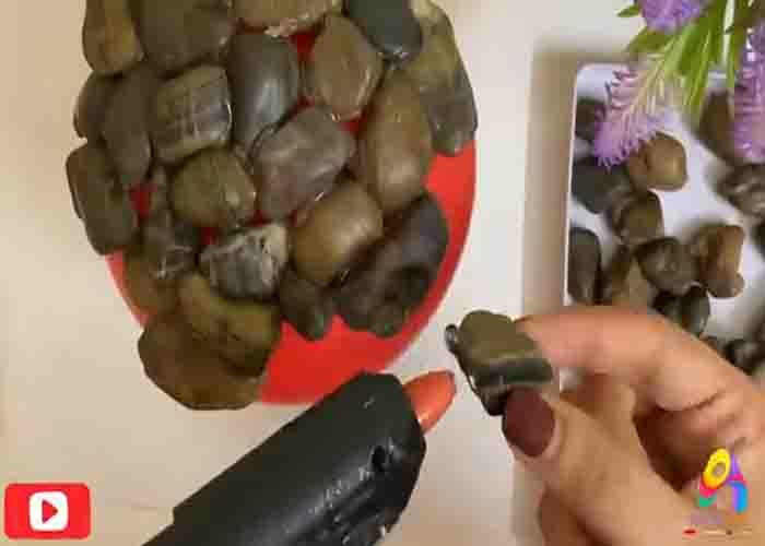 Gluing the stones on the balloon to make the flower pot