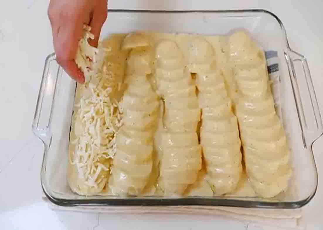 Topping the potatoes casserole with grated cheese