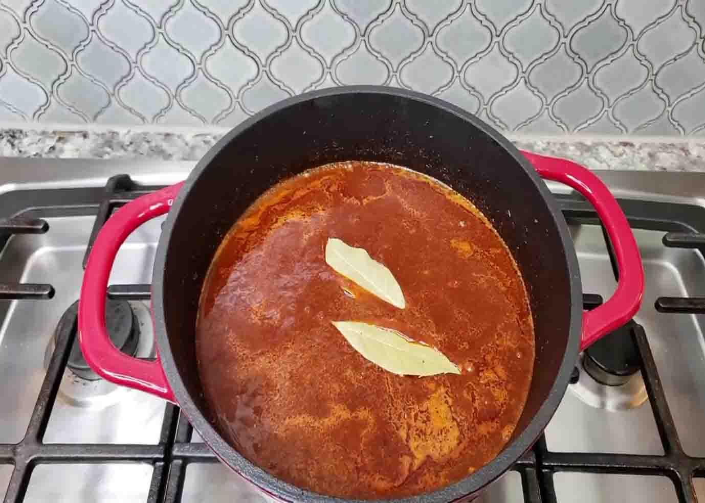 Adding bay leaves to the chili con carne