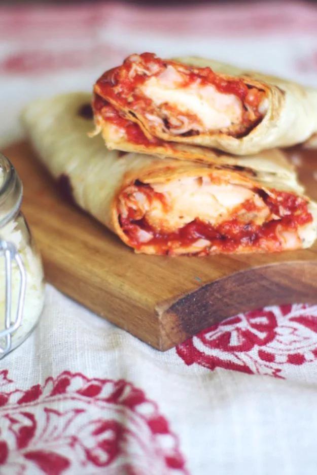 Parmesan chicken wrap griddled crisp and cut in half showing chicken, marinara and melted mozzarella