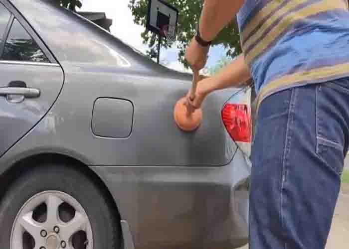 Removing the car dents using a plunger