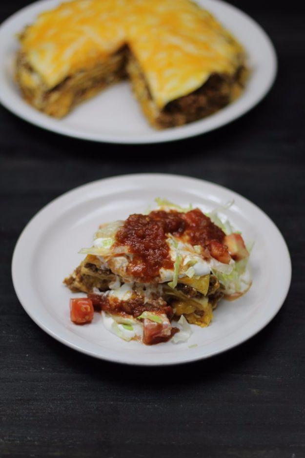 Two plates of taco pie, one wedge showing tortilla layers under melted cheese and one topped with lettuce and salsa
