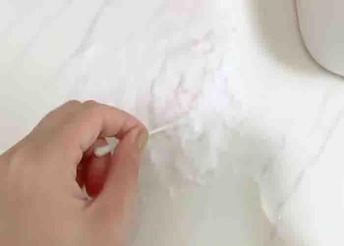 Adding the homemade paste to remove the countertop stain