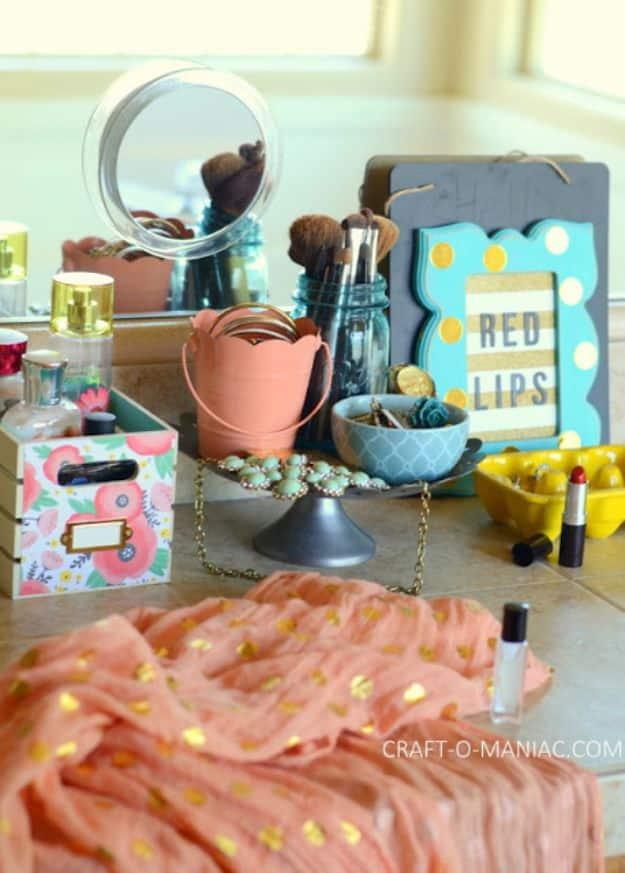 Girly beauty station with a mirror, patterned paper covered crate, brushes, jewelry and a RED LIPS sign