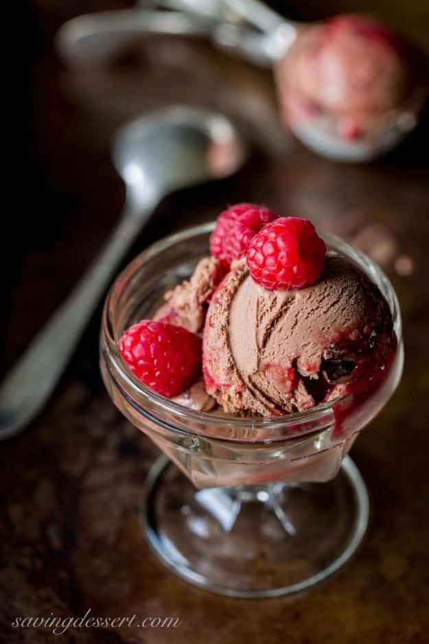 Chocolate chunk raspberry swirl ice cream with red ribbons of raspberry sauce and dark chocolate pieces