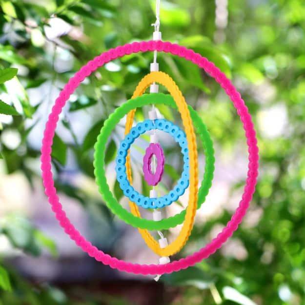 DIY perler bead rainbow wind spinners, nested pink orange yellow green and blue bead rings hanging against leaves