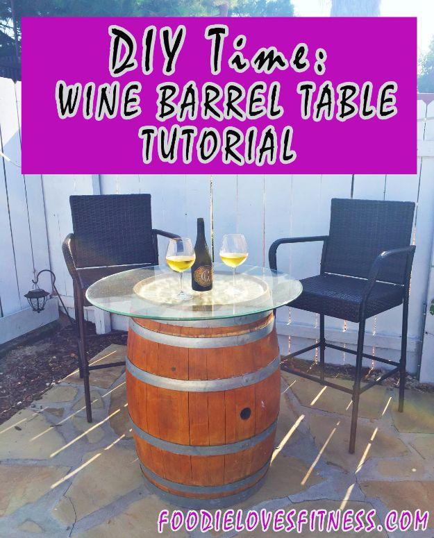 Wine barrel cocktail table with a round glass top over a cork covered barrel head, set on a patio between two chairs