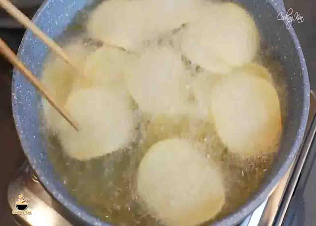 Deep frying the potatoes to make them into potato chips