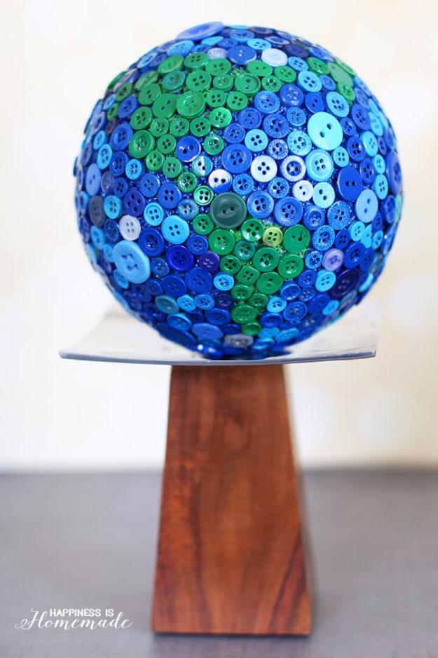 Button globe, a foam ball covered in blue and green buttons to look like a world globe on a wooden pedestal stand