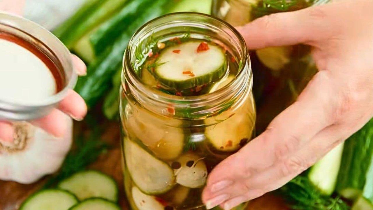 Easy overnight refrigerator pickles in a jar with cucumber spears, garlic cloves, peppercorns and fresh dill