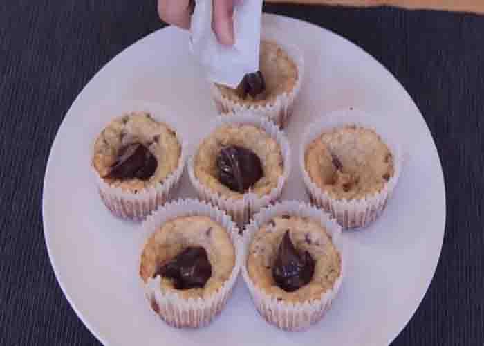 Adding the chocolate to each mini cupcake