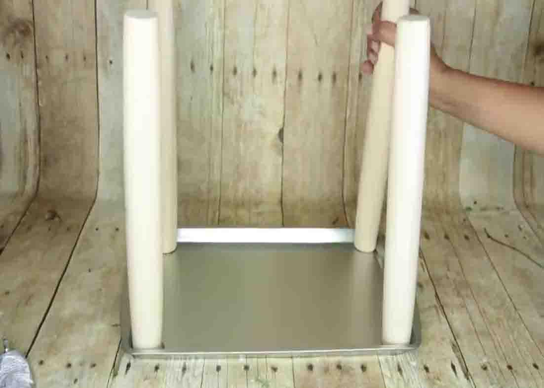 Gluing the rolling pins to the cookie sheets to make the bookshelf
