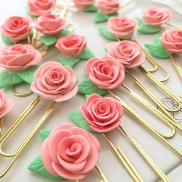 Rose clips, pink clay roses with green leaves glued to jumbo gold paperclips arranged in rows on white