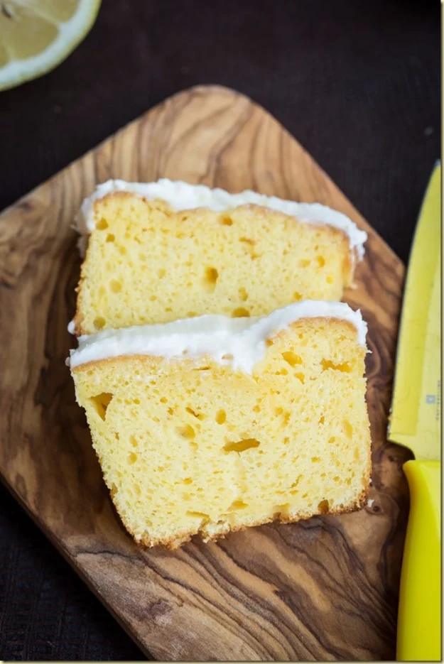 Starbucks lemon loaf cake copycat, a sliced lemon pound loaf under a thick white lemon sugar glaze on a board