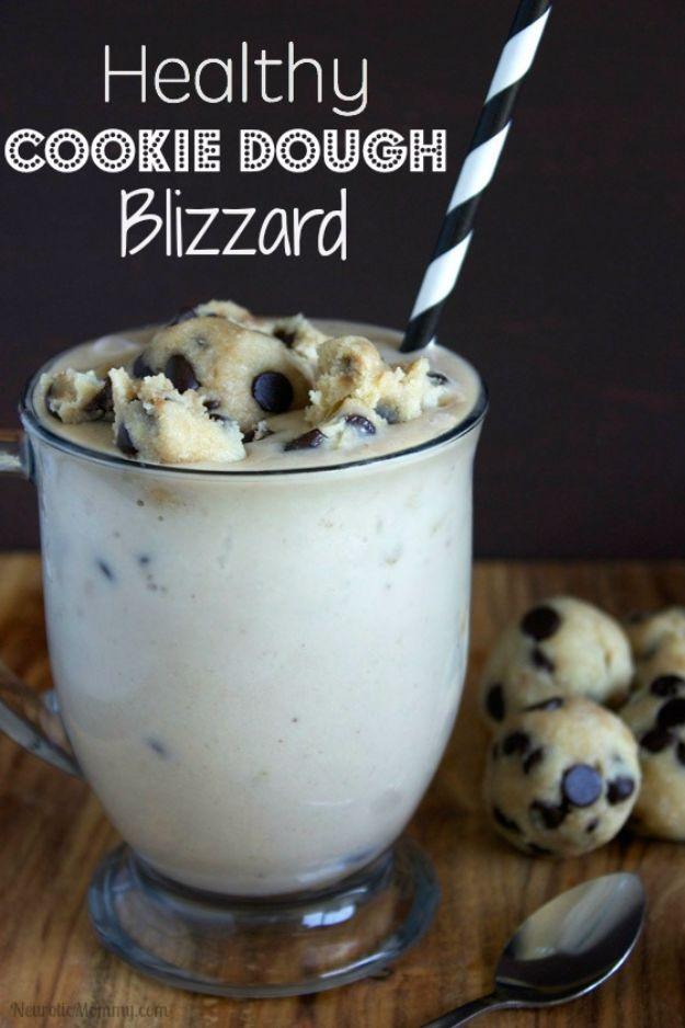 Healthy cookie dough blizzard shake in a tall glass with a striped straw and cookie dough balls beside
