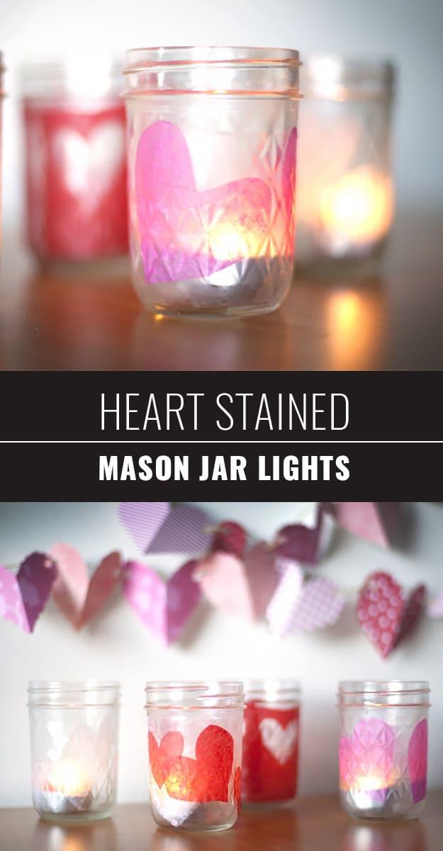 Mason jars stained with red hearts glowing from candles inside like small stained glass lanterns for Valentine's Day