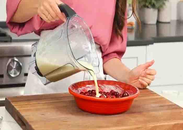 Transferring the cherry clafoutis batter into the prepared pan