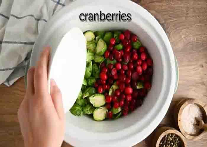 Adding the brussels sprouts and cranberries in the slow cooker
