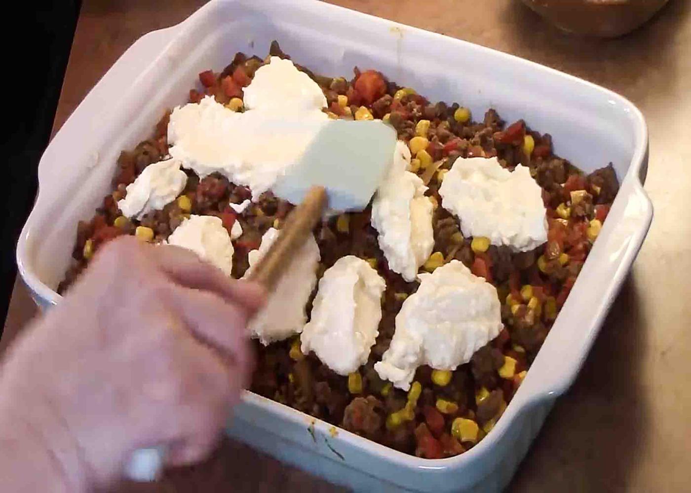Dolloping the cream cheese mix over the top of the john wayne casserole